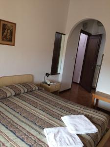 a bedroom with a bed and a dresser at Hotel Bodoni in Florence