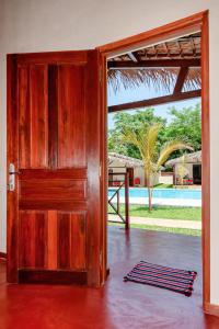 an open wooden door with a view of a pool at Blue Sky Resort in Nosy Be +97 photos