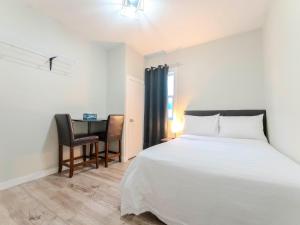 a bedroom with a white bed and a desk at Luvienna Stays in Winnipeg