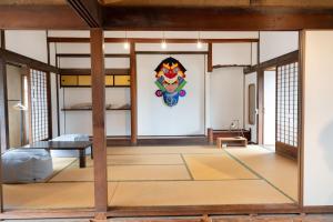 a room with bunk beds and a painting on the wall at 泊れる図書館 さんごさん in Goto
