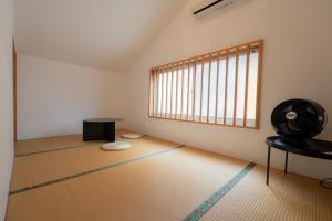 an empty room with a fan and a table at 泊れる図書館 さんごさん in Goto +15 photos