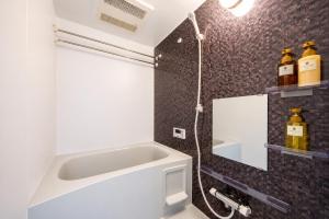 a bathroom with a shower with a sink and a mirror at Hotel Piacere NAMBA in Osaka +32 photos