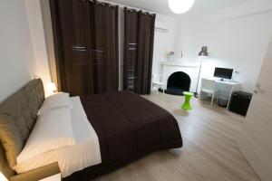 een slaapkamer met een bed en een woonkamer met een open haard bij Affittacamere Amato in Corigliano Calabro