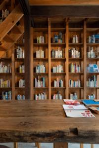 a wooden table in a library with books at 泊れる図書館 さんごさん in Goto