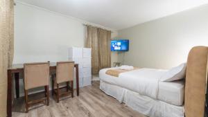 a hotel room with a bed and a desk and a tv at Luvienna Stays in Winnipeg