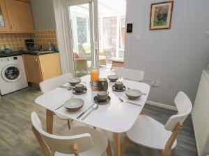 ein weißer Tisch und Stühle in einer Küche in der Unterkunft Lamora in Cheddar