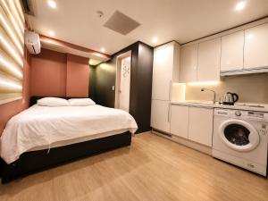 a bedroom with a bed and a washing machine at November Myeongdong in Seoul