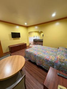 a hotel room with a bed and a flat screen tv at Sunrise Inn in South Gate