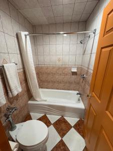 a bathroom with a toilet and a bath tub at Sunrise Inn in South Gate +17 photos