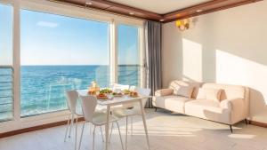 a living room with a table and chairs and a couch at GoSeong Beach Jin Spa Pension in Goseong