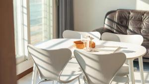a white table and chairs in a room with a window at GoSeong Beach Jin Spa Pension in Goseong