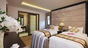 a hotel room with two beds and a bathroom at Athena Hotel in Ho Chi Minh City