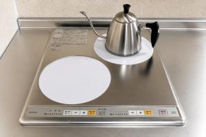 a tray with a tea kettle on top of a stove at Hotel Piacere NAMBA in Osaka