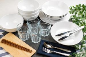 a table with white plates and glasses on it at Hotel Piacere NAMBA in Osaka