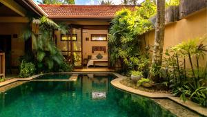 a swimming pool in a garden with a house at Samadhi by the Venus Project in Ranna