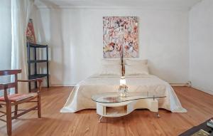 a bedroom with a bed with a table and a painting at Charmante Maison 