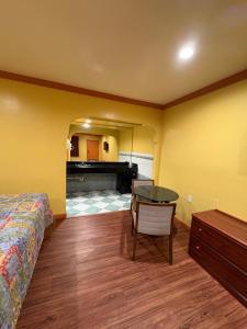 a bedroom with a bed and a table and a piano at Sunrise Inn in South Gate