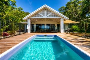 a swimming pool in front of a house at Cairns Beachfront Retreat in East Trinity