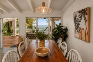a dining room with a wooden table and chairs at Cairns Beachfront Retreat in East Trinity