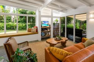 a living room with a couch and a table at Cairns Beachfront Retreat in East Trinity