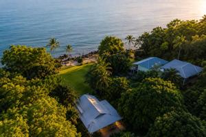 an aerial view of a house with the ocean in the background at Cairns Beachfront Retreat in East Trinity