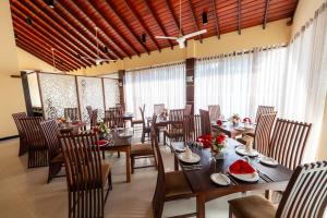 a dining room with tables and chairs and windows at Riverdale lagoon villas in Aluthgama