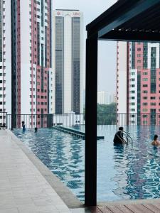 a group of people in a swimming pool with tall buildings at Chambers Elite Suites KLCC in Kuala Lumpur