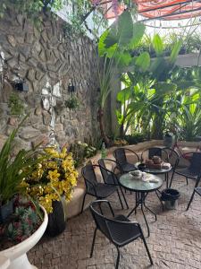 a patio with tables and chairs and a stone wall at She Stay in Hòa Bình