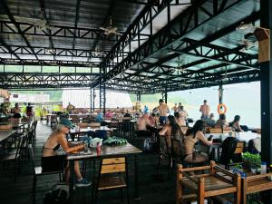 a group of people sitting at tables on the beach at Keereethara chiewlarn in Ban Bang Kaeo