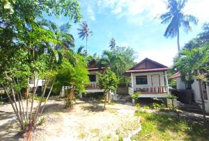 a house with palm trees in front of it at Koh Tao Townhouse in Ko Tao