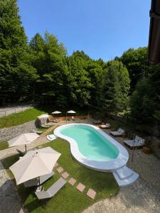 a large swimming pool with umbrellas and chairs at Cabana Xtreme - Valiug in Văliug