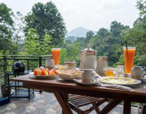 a wooden table with food and drinks on it at Rivinu Holiday Resort in Ella