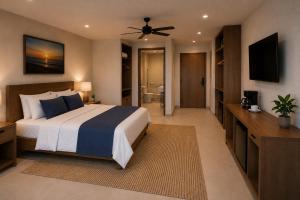 a bedroom with a bed and a television and a bathroom at Posada Blue Sunset in Santa Cruz