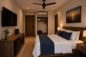 a bedroom with a bed and a flat screen tv at Posada Blue Sunset in Santa Cruz