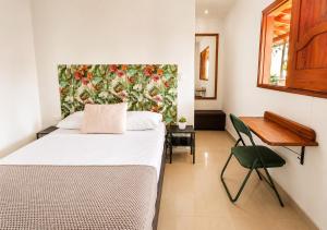 a bedroom with a bed and a table and a desk at Hotel Jardin de Rosas in Jardin