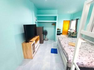 a bedroom with a bed and a television on a cabinet at Koh Tao Townhouse in Ko Tao