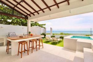 an outdoor kitchen and dining area with a view of the ocean at Alesea Baroro, La Union, Private Modern Villa with Pool, Jacuzzi, Beachfront View in Balio