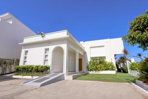 a white house with a driveway in front of it at Alesea Baroro, La Union, Private Modern Villa with Pool, Jacuzzi, Beachfront View in Balio