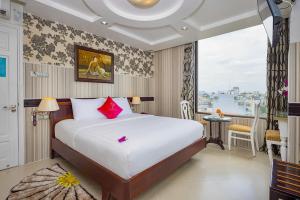 a hotel room with a bed and a large window at Pink Suite Saigon Airport Hotel in Ho Chi Minh City +58 photos