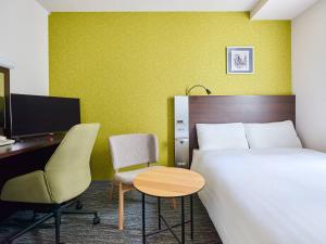 a hotel room with a bed and a desk and a computer at Comfort Hotel Sendai West in Sendai +33 photos