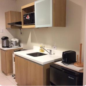 a kitchen with a sink and a microwave at 1BR Condo Unit in Pico De Loro in Nasugbu