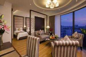 a hotel room with a bedroom and a bed and a table at Athena Hotel in Ho Chi Minh City