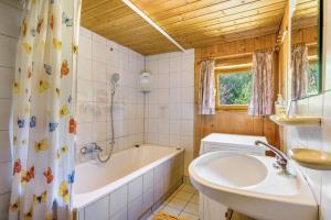 a bathroom with a tub and a sink at Haus Winterstaude in Egg
