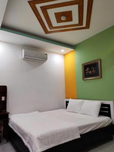 a bedroom with a white bed with colorful walls at Khách sạn Tuyết Minh in Xã Thang Tam +3 photos