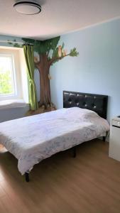 a bedroom with a bed with a tree on the wall at Fancy home in Richmond hill in Richmond Hill