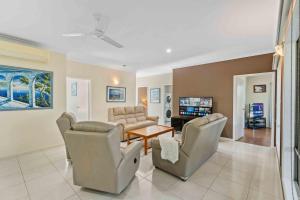 a living room with couches chairs and a table at The Seahaven - Modern 5 Bedroom Family Home Close to Beach in Pialba