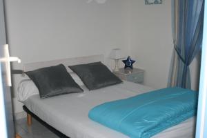 a bedroom with a large bed with blue sheets and pillows at La Doris gîte de mer in Saint-Pair-sur-Mer