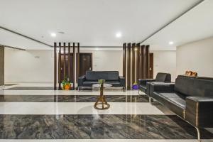 a lobby with black leather furniture and a table at Hotel O D Suites in Hyderabad