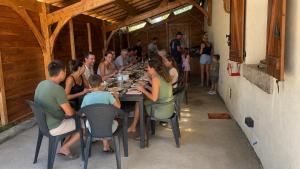 a group of people sitting at a long table at Gite 15 pers tout compris Les Lucioles in Crevant