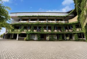a building with plants on the side of it at Townhouse Oak Hotel Lestari in Berpodak +43 photos